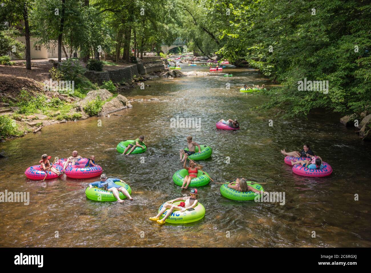 Families enjoying a relaxing summer day tubing through Downtown Helen