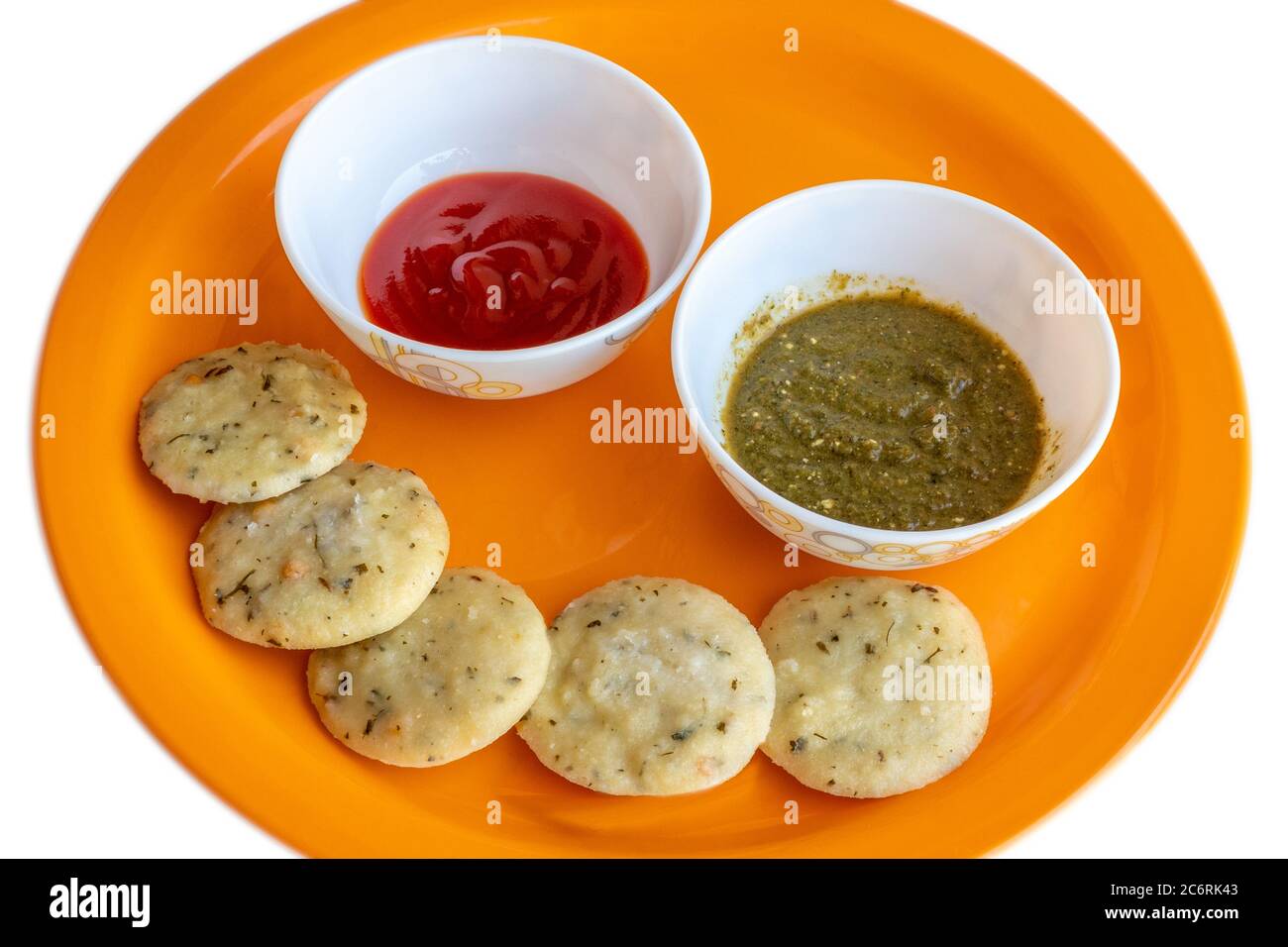 Idli (south indian recipe) with hot chilli sauce and green chutney. Stock Photo