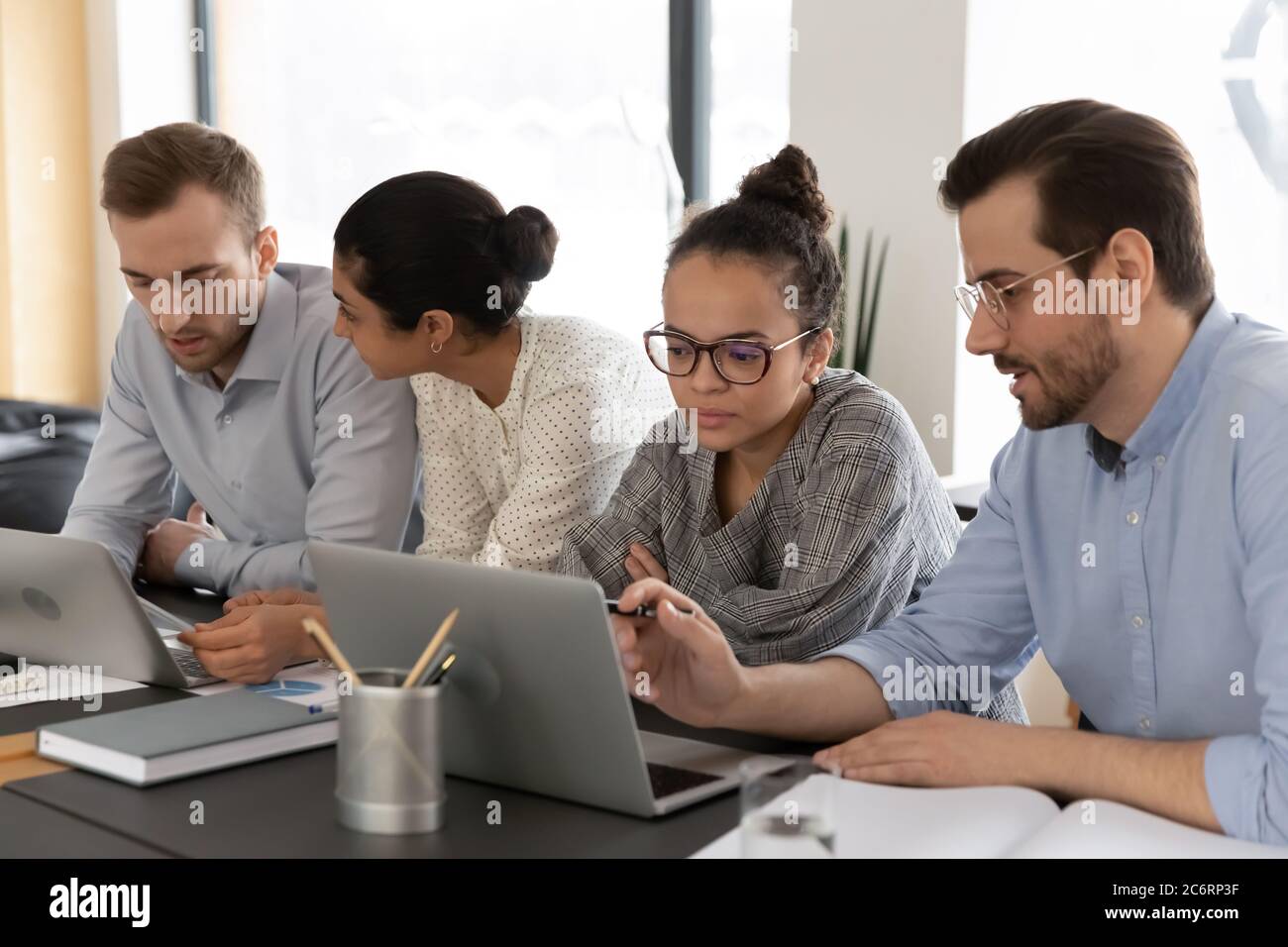 Diverse colleagues work on laptops at office meeting Stock Photo - Alamy