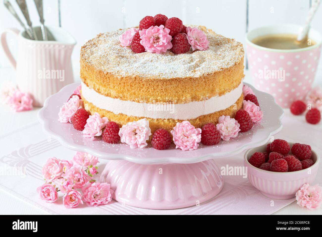 raspberry cream cake decorated with pink roses on cake plate Stock Photo