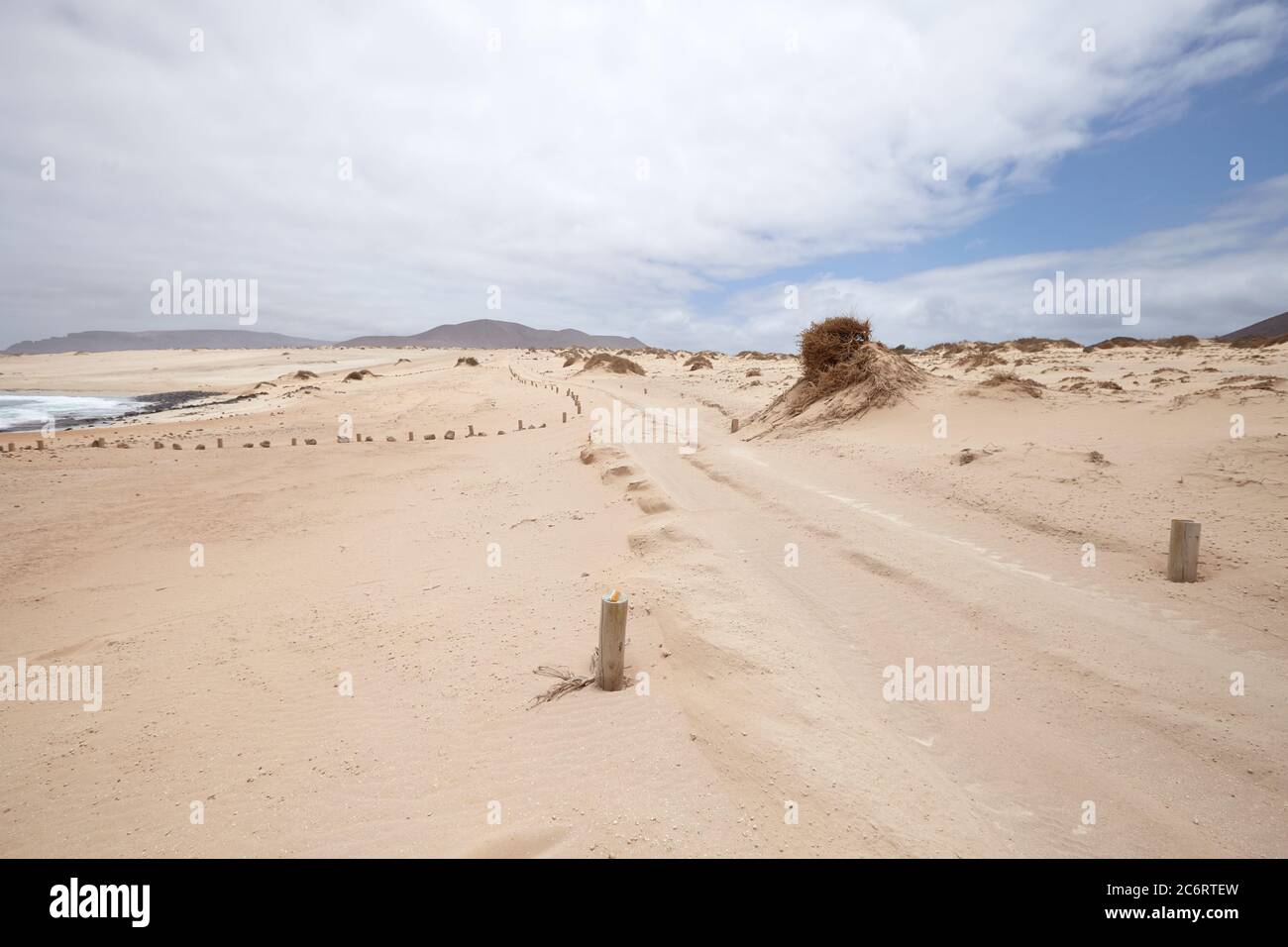 Sandy path along the beach on the island of La Graciosa, in Spain. Atlantic waters bathe the shores of a sandy path. Stock Photo