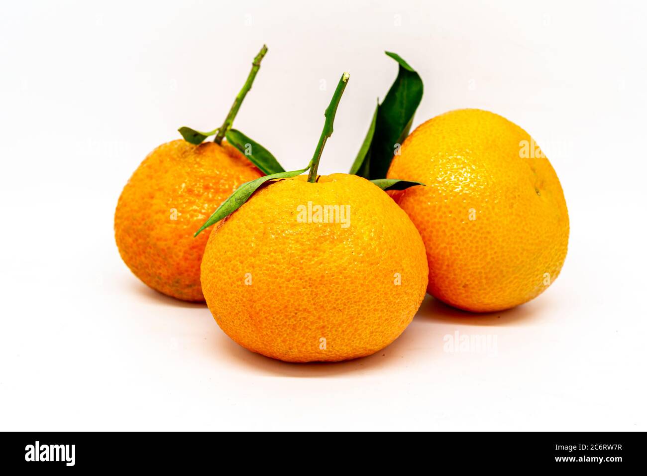 Clementines with leaves isolated against a white background Stock Photo