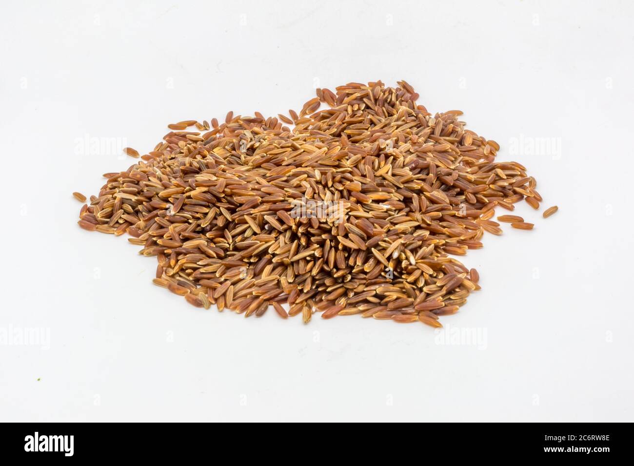 A pile of uncooked red rice against a white background Stock Photo - Alamy