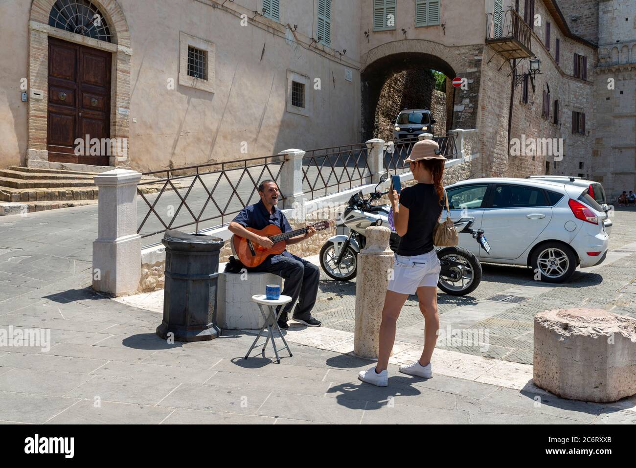 assisi,italy july 11 2020:a street artist with a guitar in the sun Stock Photo