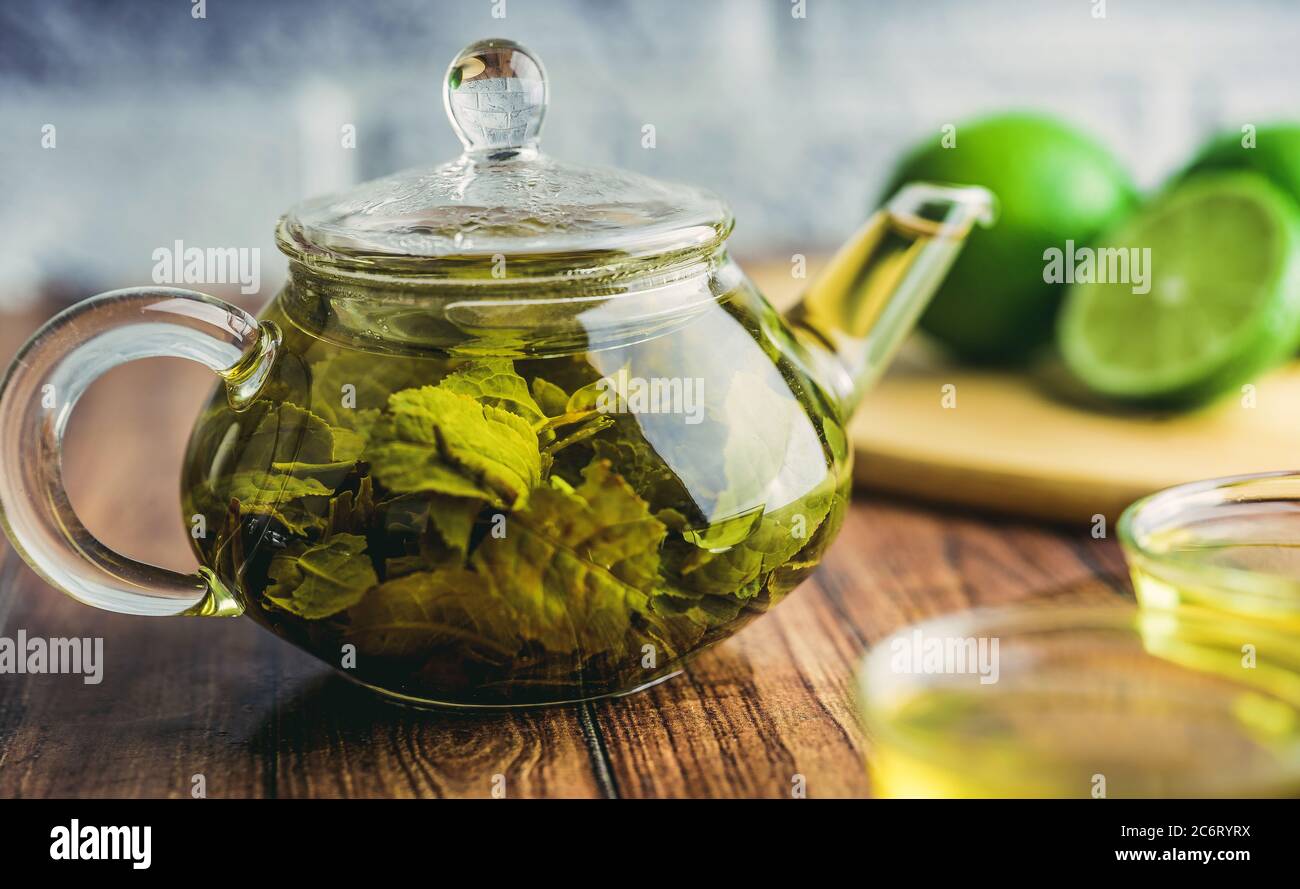 The tea leaves are brew in boiling water and infuse in a small teapot. The concept of the tea party. Green tea in a teapot Stock Photo