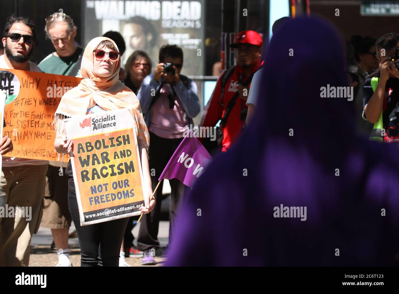 Lydia who appeared on SBS’s ‘Living with the Enemy’ speaks at the rally against ‘Islamophobia’ outside Sydney Town Hall as protesters hold signs. Stock Photo