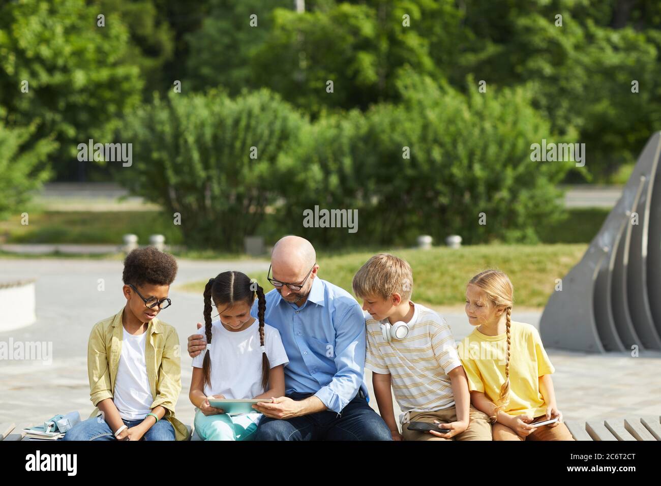 Front view at multiethnic group of children using tablets and