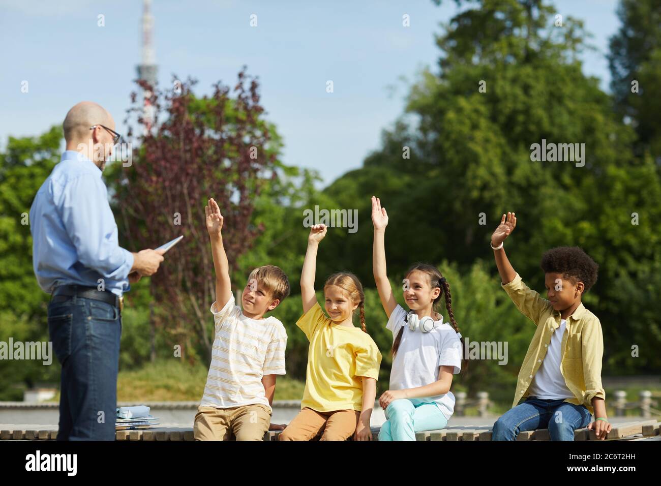 Kids raising hands in class hi-res stock photography and images - Alamy