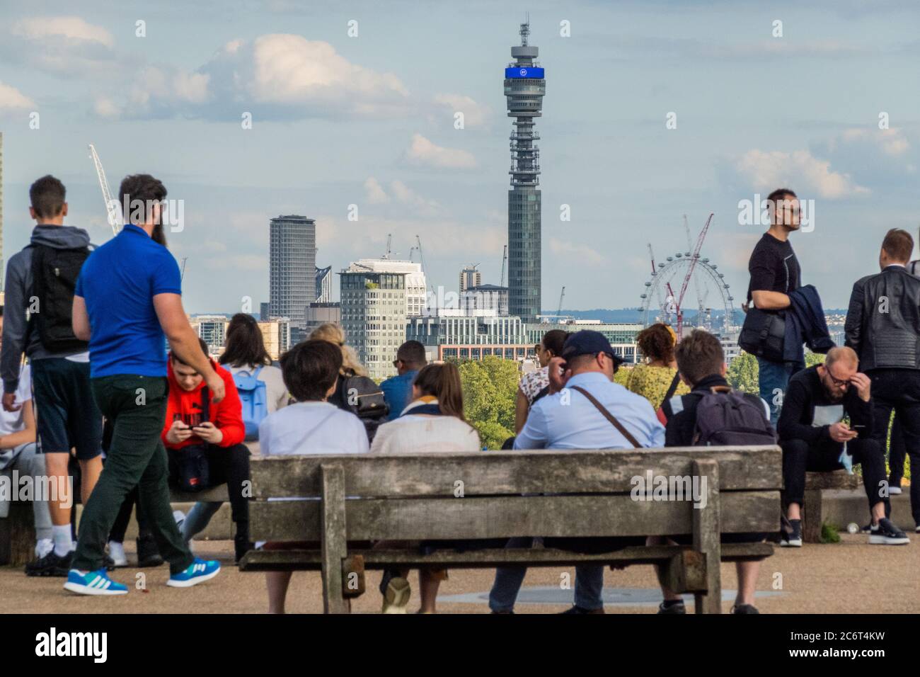 London, UK. 11th July, 2020. The BT tower continues to display the government's message of 'Stay Alert, Control the Virus' - People enjoy a sunny evening on Primrose Hill overlooking the city. The 'lockdown' continues to be eased for the Coronavirus (Covid 19) outbreak in London. Credit: Guy Bell/Alamy Live News Stock Photo