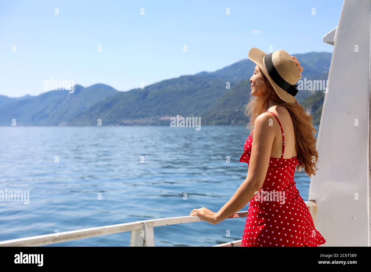 Traveler tourist woman enjoying breeze relaxing on a cruise boat Lake Como Stock Photo