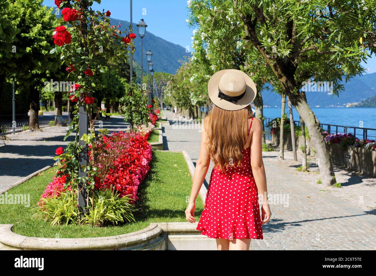 Charming girl walking along Lake Como on flowered street of Bellagio, Italy Stock Photo
