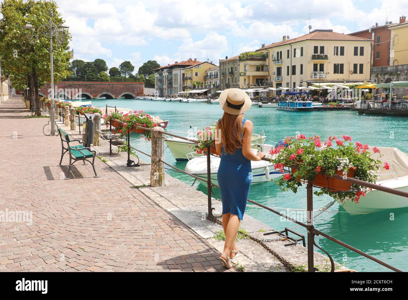Travel in Italy. Back view of beautiful fashion girl enjoying visiting Lake Garda. Summer holidays in Italy. Stock Photo