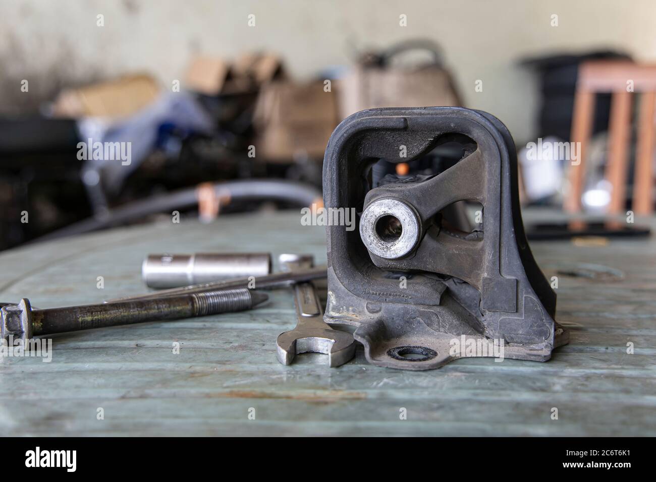 Old rubber engine mount with tools on the table background. Stock Photo
