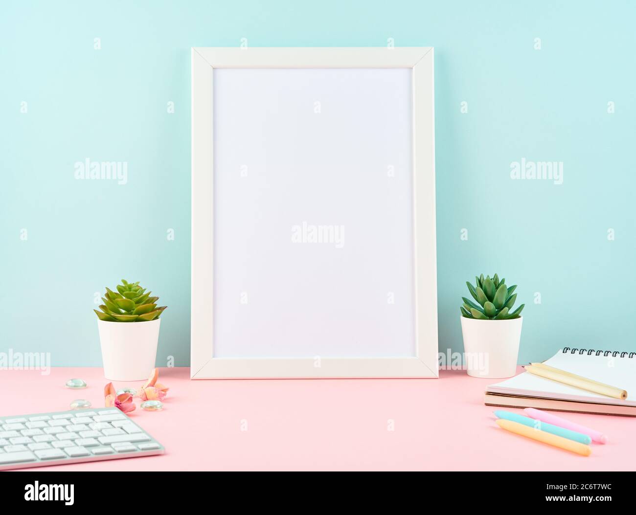Mockup with blank white frame, alarm, notepad, keyboard on pink table Stock Photo