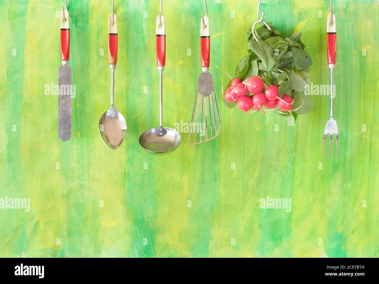 a bunch of fresh radish and hanging vintage kitchen utensils , helathy eating,vegetarian,cooking concept, free copy space Stock Photo