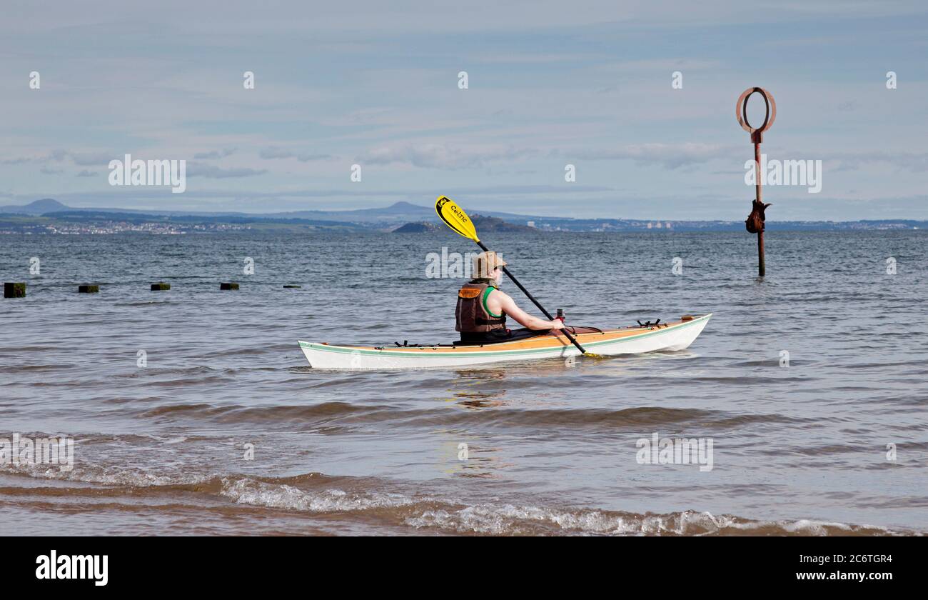 Portobello, Edinburgh, Scotland, UK 12 July 2020.Temperature 13 degrees in the morning rising to 18 degrees in afternoon with very little breeze. Pictured: Watersport on  kayak popular over the last three months of the Coronavirus pandemic as people of all ages have healthier pursuits in their leisure time as well as the regular wild swimmers taking a dip in the Firth of Forth. Stock Photo