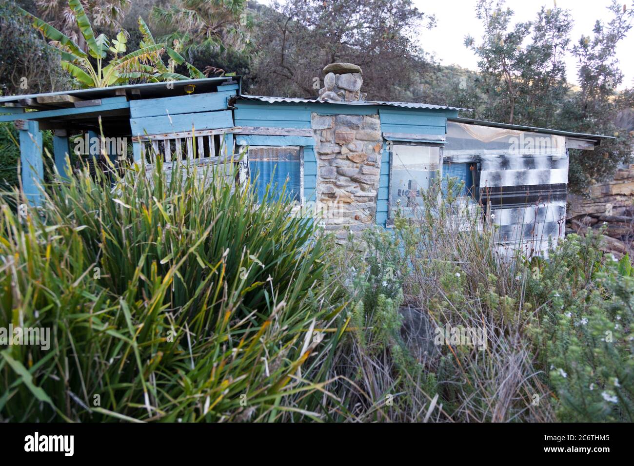 A historic old clifftop hut  at an isolated cove in the National Park bushland of Sydney, Australia Stock Photo
