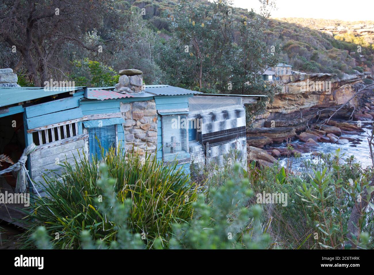 Historic old clifftop huts  on an isolated cove in National Park bushland of Sydney, Australia Stock Photo