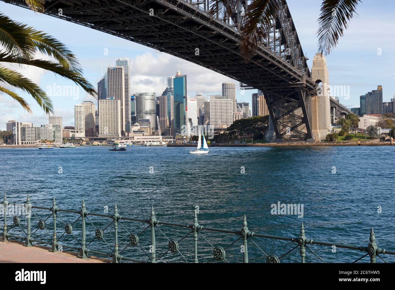 View of the city and Sydney harbourside taken from under the iconic harbour bridge at water level. Stock Photo