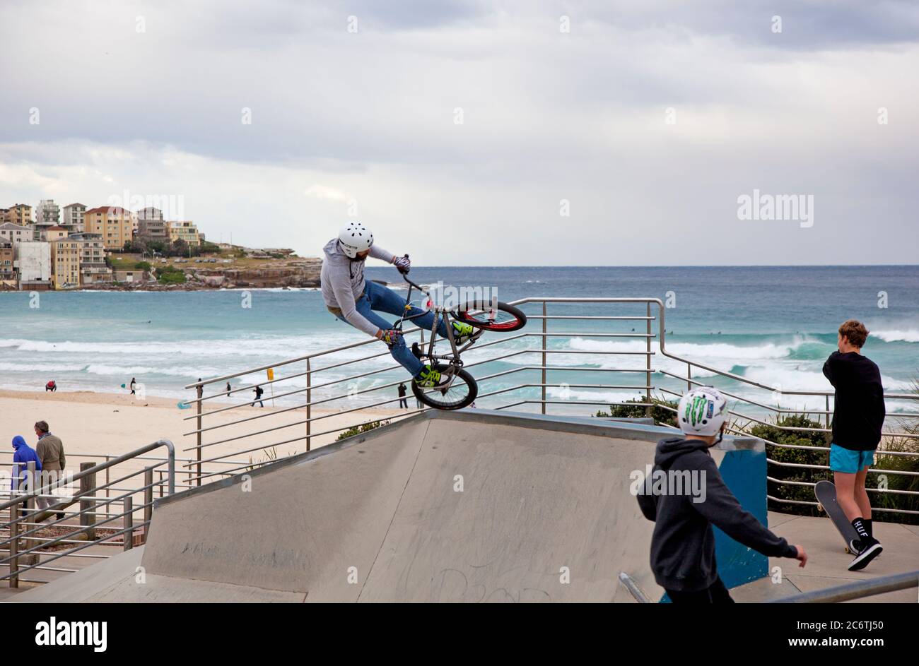 A helmetted rider doing bike stunts in the skateboard and bike park on Bondi Beach, Sydney Stock Photo