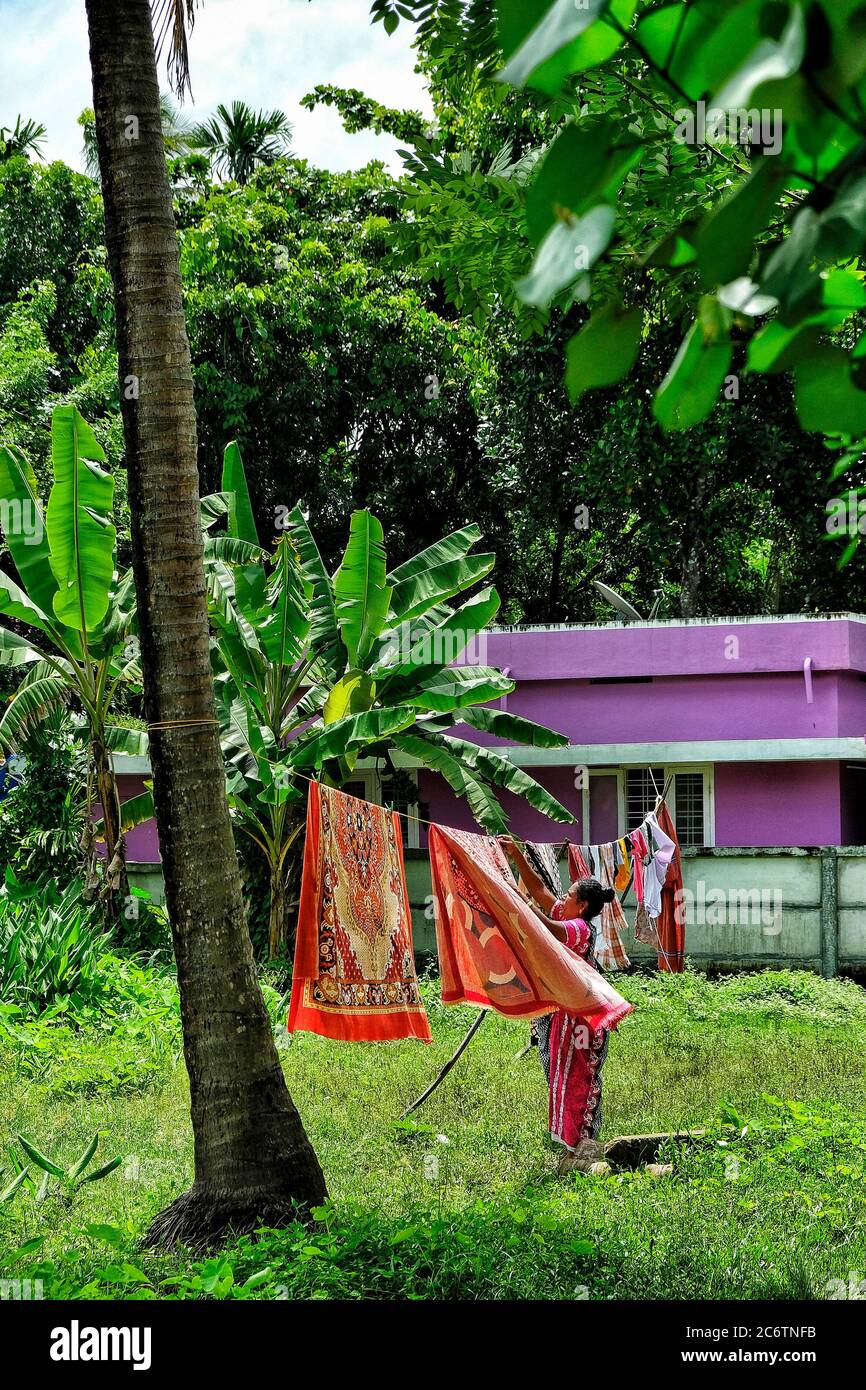 Fort Kochi, India - July 2020: Woman hanging clothes at Fort Kochi on July 6, 2020 in Kerala. India. Stock Photo