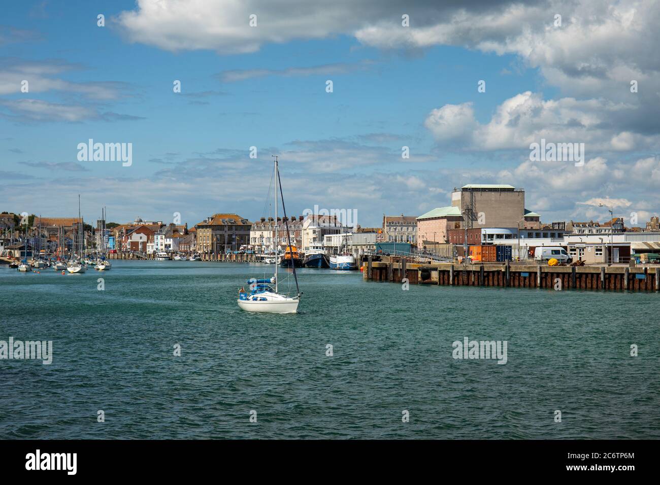 A yacht leaving Weymouth harbour, Weymouth, England, UK Stock Photo