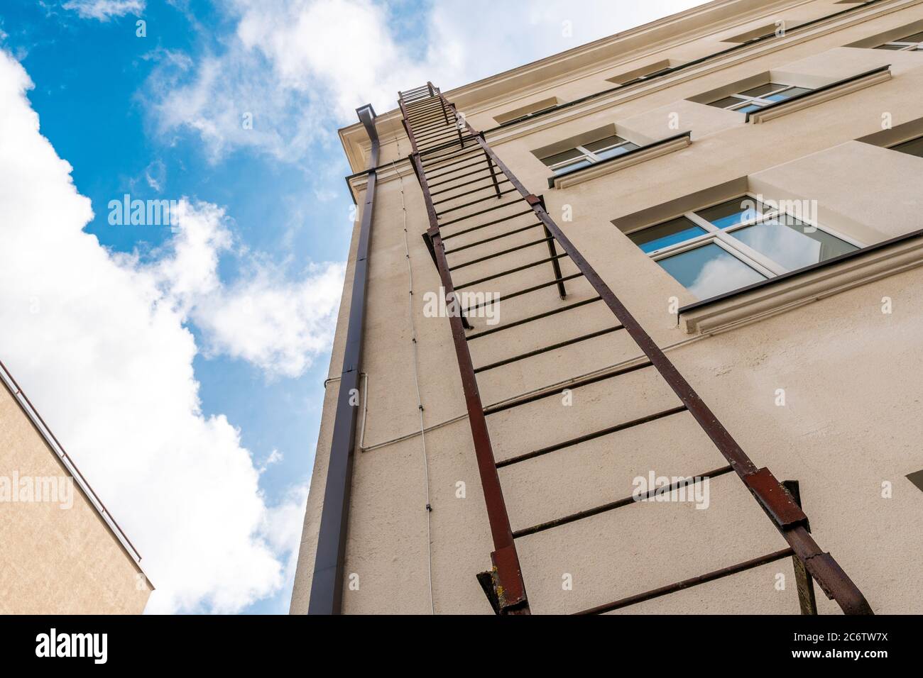 Fire escape leading to the roof of the house. Fire escape ladder or emergency  exit with steel staircase on wall of building Stock Photo - Alamy