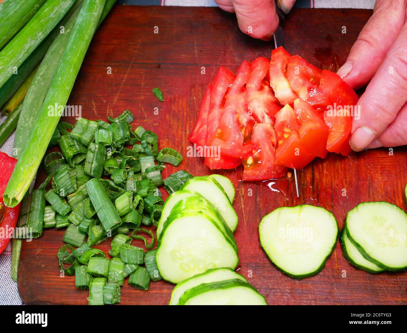 Slicing a red tomato with a knife on a cutting board Stock Photo - Alamy