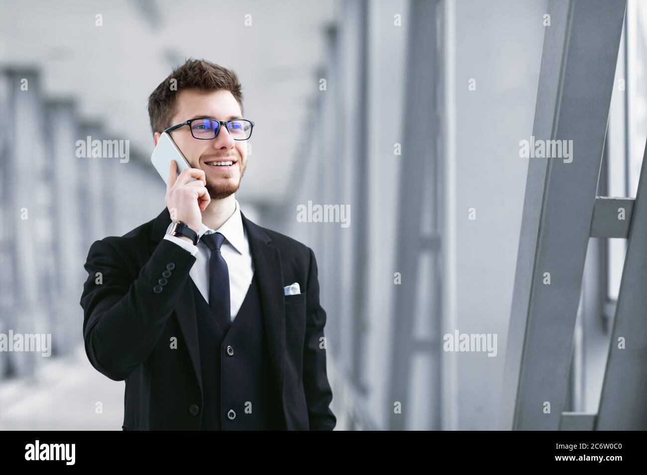 Smiling business man talking on smartphone wearing specs Stock Photo