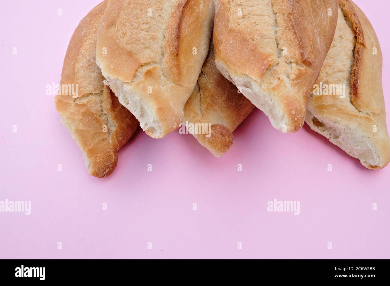 Loaves of Mexican white bread, Bolillo Fleima, traditional Mexican from the state of Jalisco baguette on a pink background Stock Photo