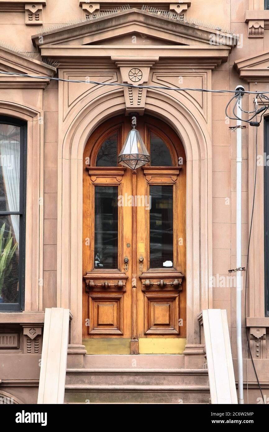 Double wooden vintage arched entry door decorated with keystone