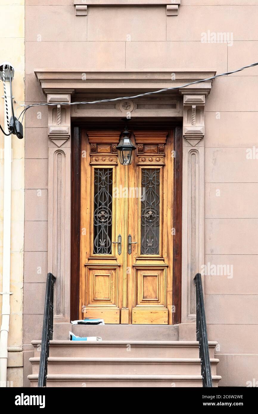 Wooden vintage entry door decorated with pilasters and corbels. New York. USA. Stock Photo
