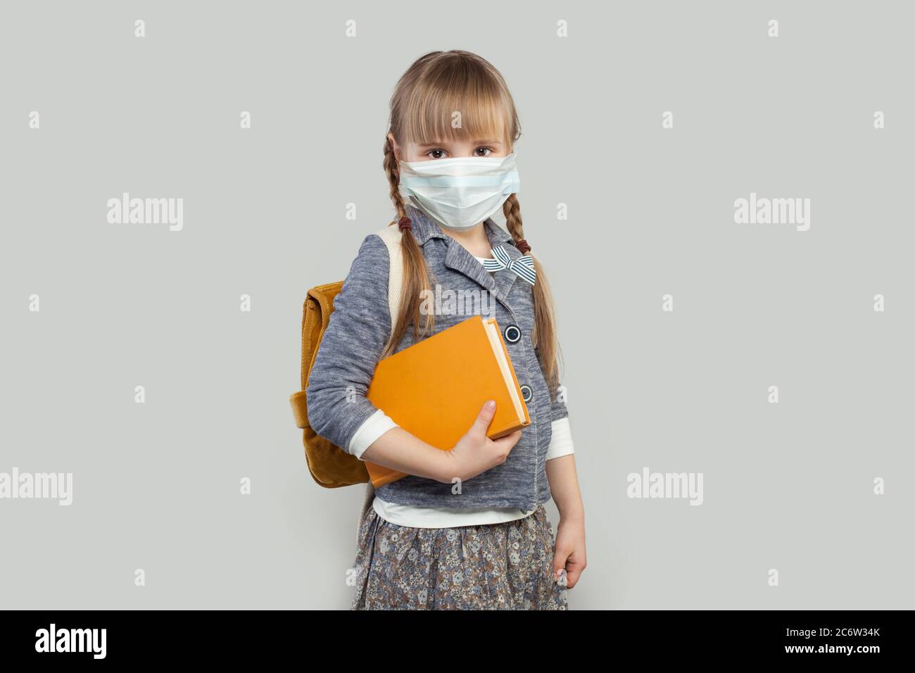 Cute little girl wearing medical protective face mask on white ...