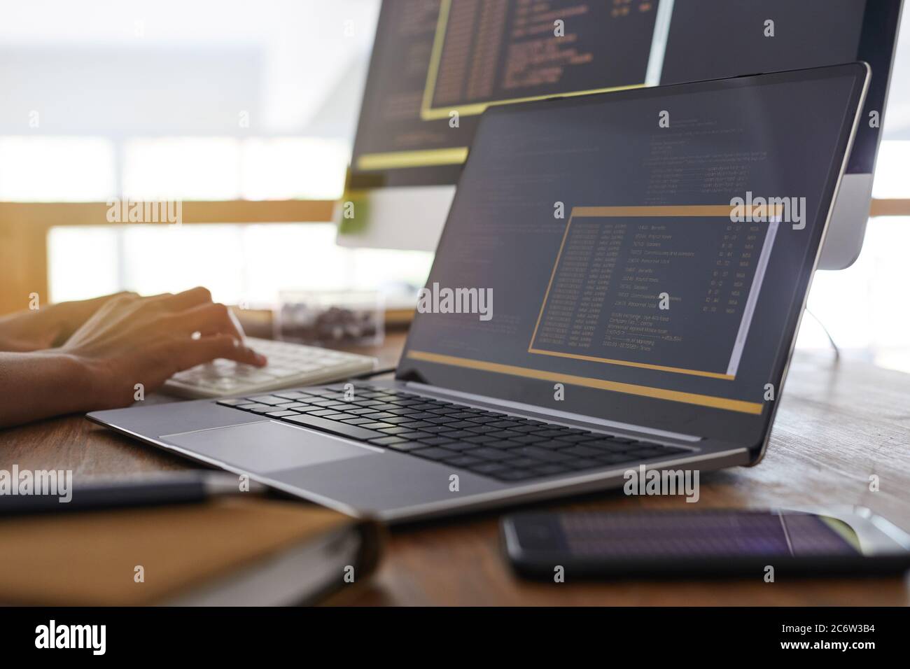 Background image of male hands typing on keyboard with black and orange ...