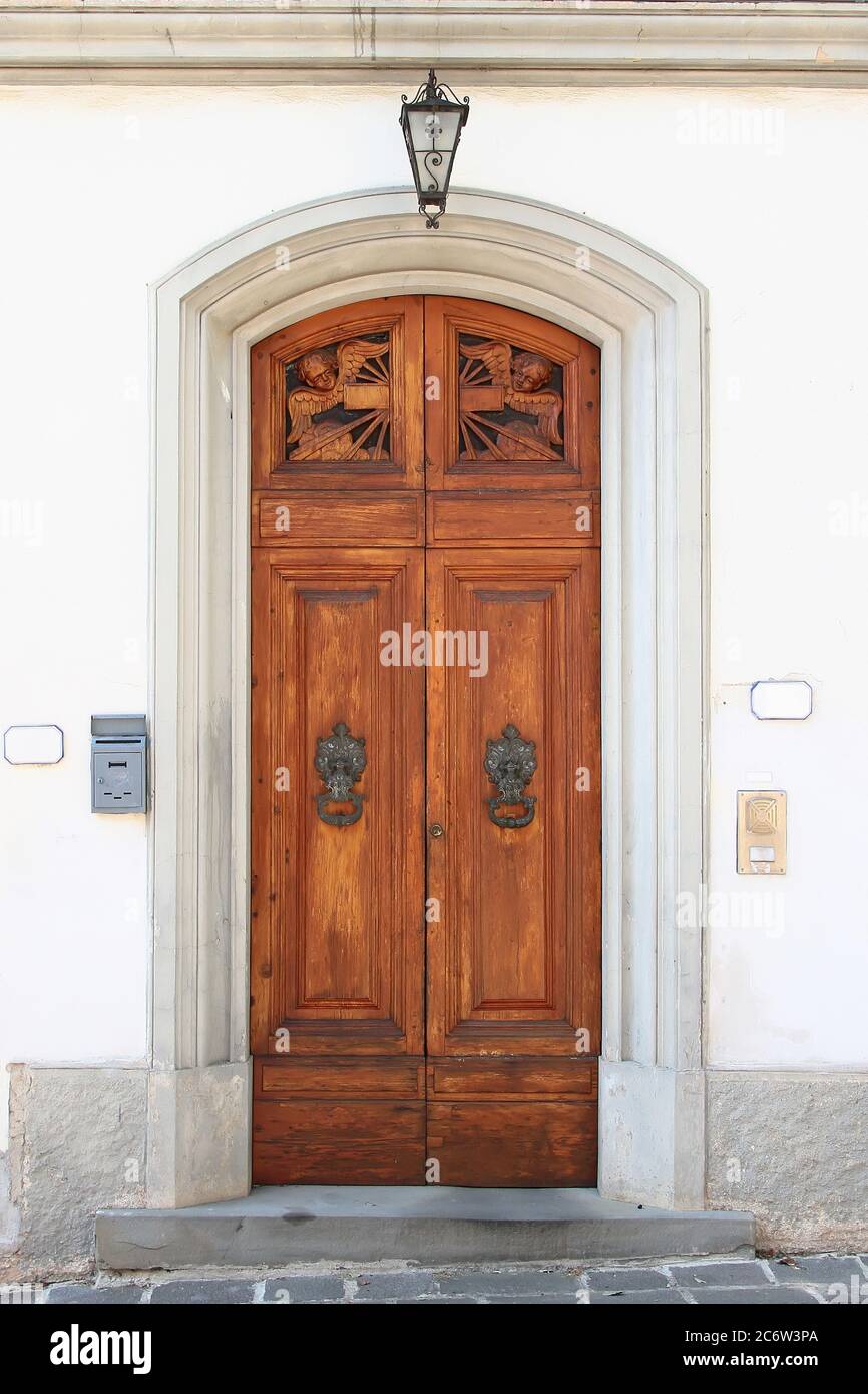 Wooden vintage entry door decorated with carved sculptures, arch and  molding. Vinci. Italy Stock Photo - Alamy