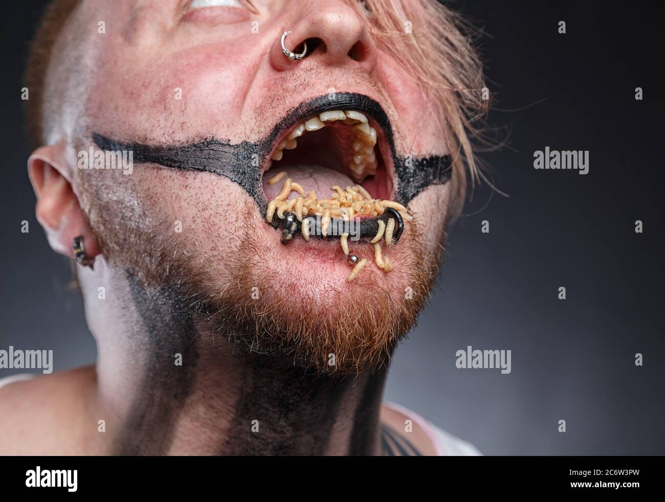 Scary mad man with maggots in his mouth Stock Photo