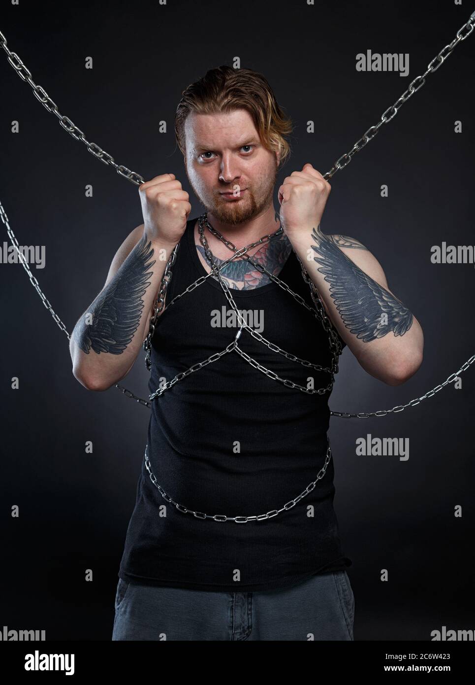 Photo of a brutal man bound in chains Stock Photo