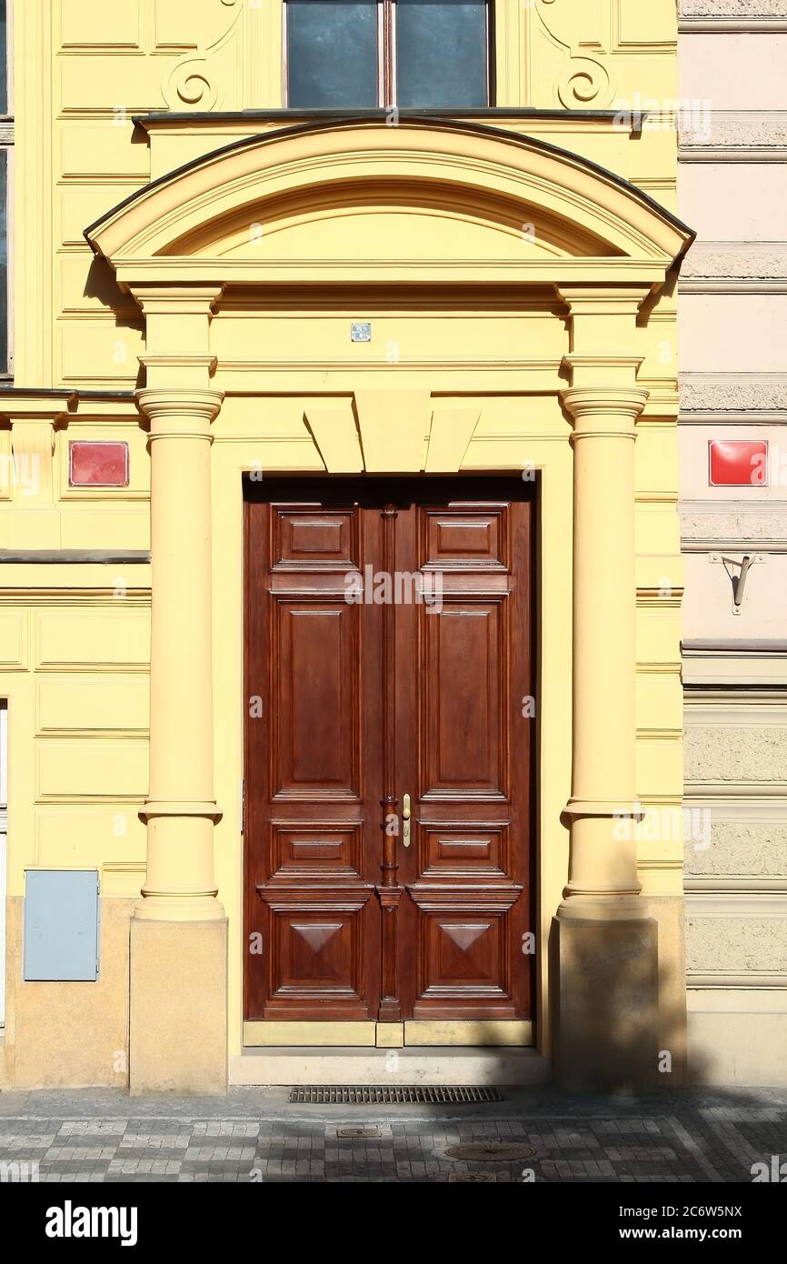 Wooden vintage entry door decorated with arch and tuscan order columns. Prague. Czech Republic. Stock Photo