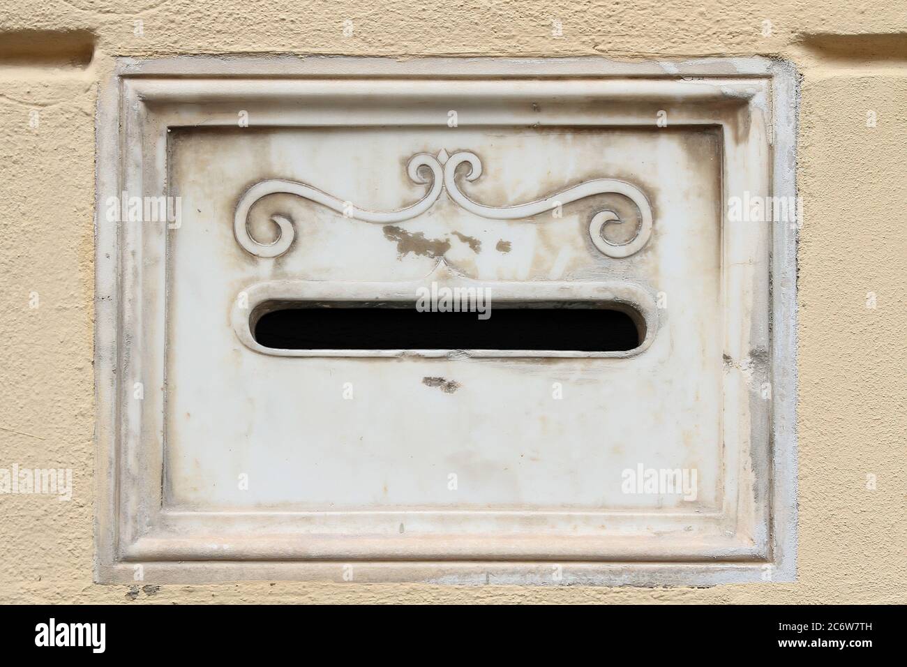 Decorative element. Vintage marble built-in mailbox decorated with embossed ornate scroll . Pisa. Italy. Stock Photo