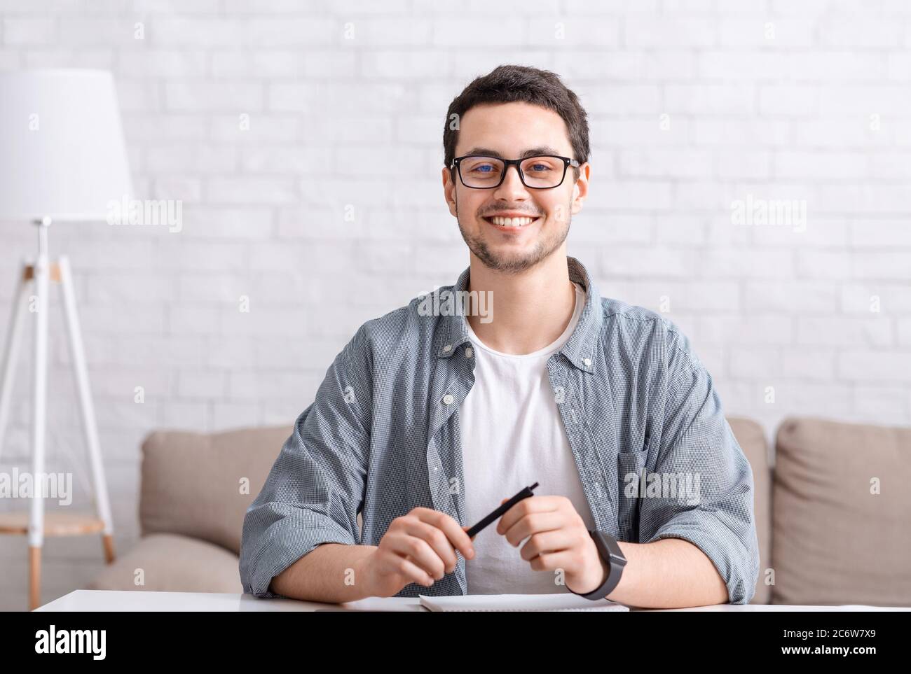 Online conference with team or chatting with followers. Man with glasses looks at webcam Stock Photo