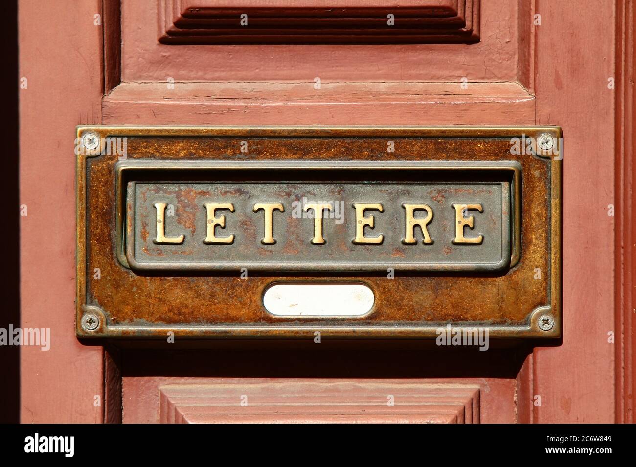 Decorative element. Vintage brass built-in mailbox with text 'lettere'. Pisa. Italy. Stock Photo