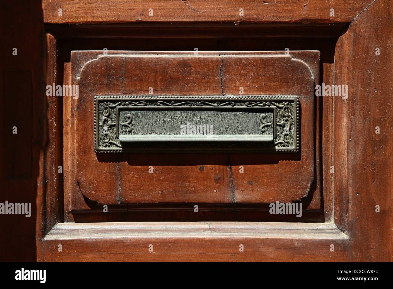 Decorative element. Vintage brass built-in mailbox decorated with embossed ornate scrolls . Volterra. Italy. Stock Photo