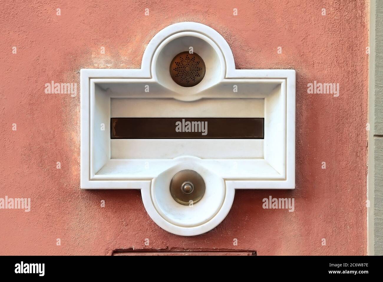 Decorative element. Vintage marble built-in mailbox with brass button and speaker. Pisa. Italy. Stock Photo