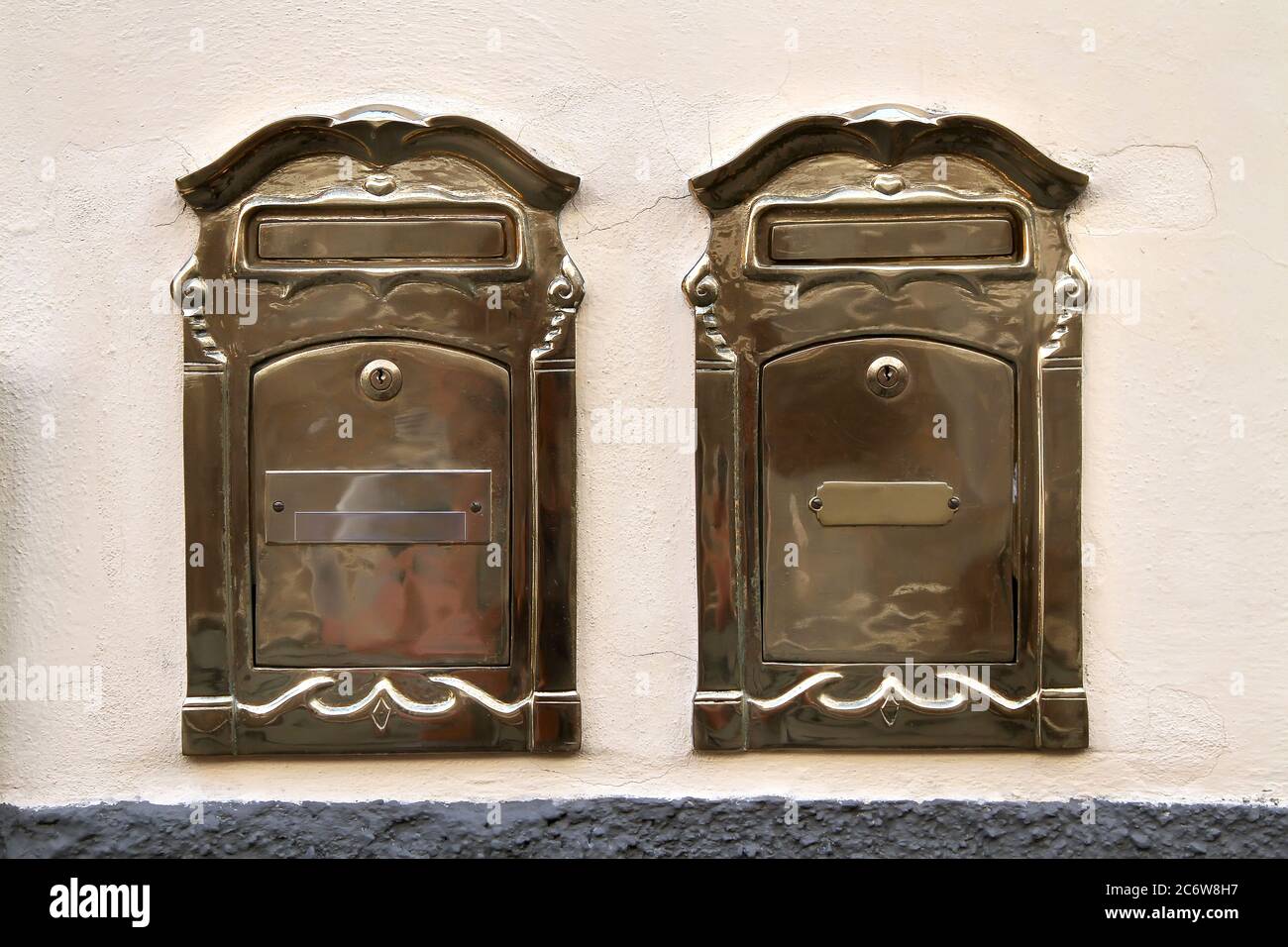 Two oldstyle brass mailboxes with locks and nameplates. Pisa. Italy. Stock Photo