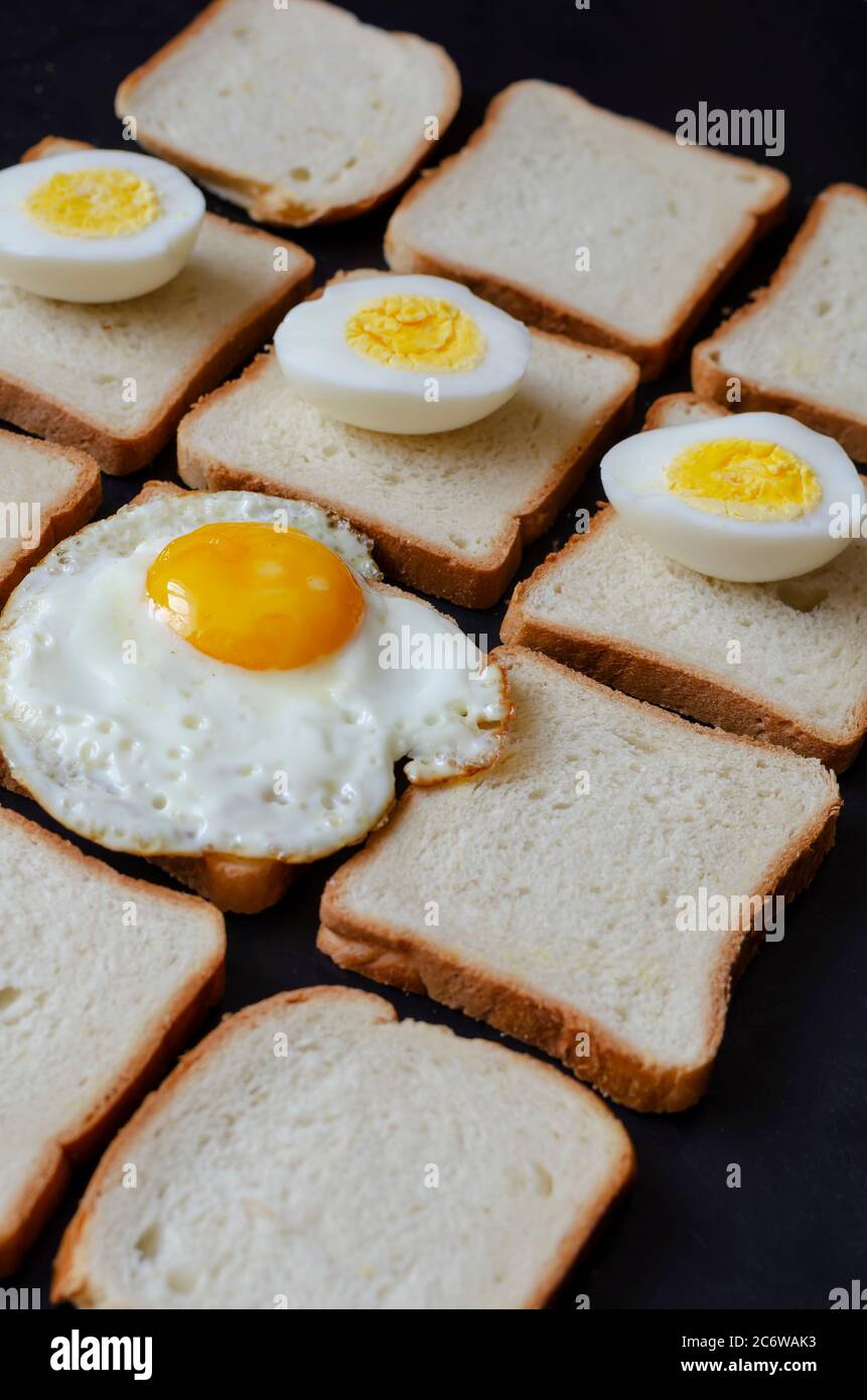Ready to eat eggs on slices of bread for toast. Fried eggs from one egg and half boiled eggs. Traditional food. Selective focus. Stock Photo