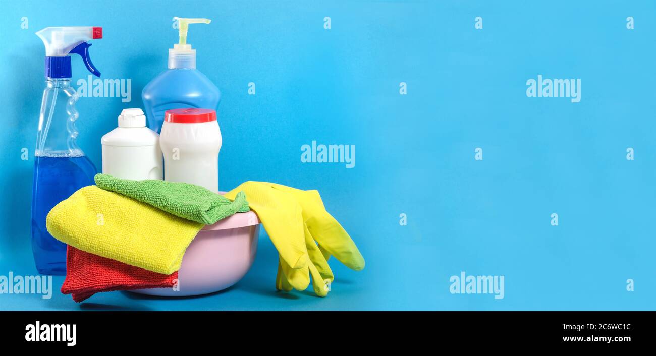 Background banner with home cleaning products with colorful napkins on a blue background with copy space. Cleaning in the house Stock Photo