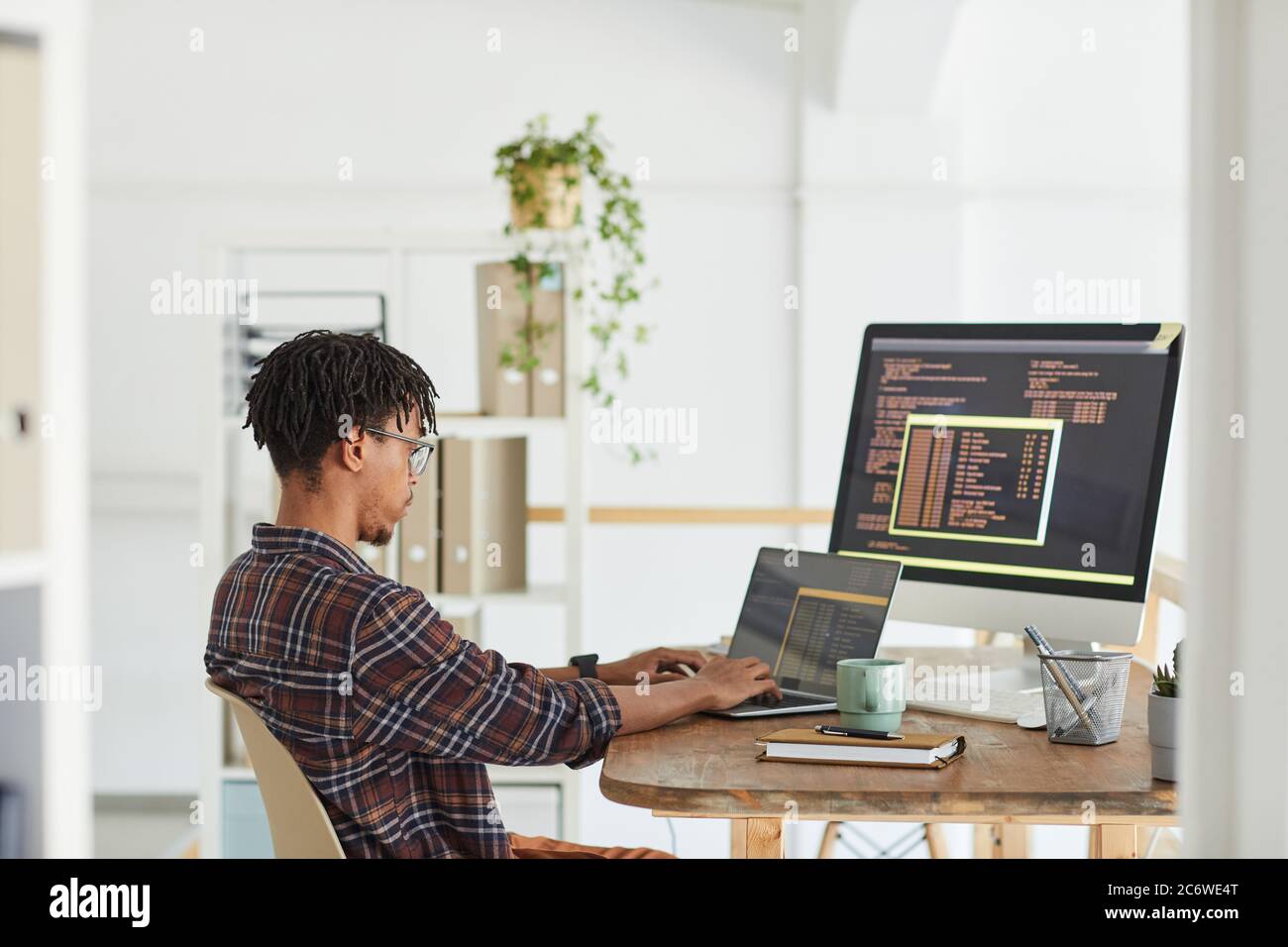 Side view at African-American IT developer typing on keyboard with ...