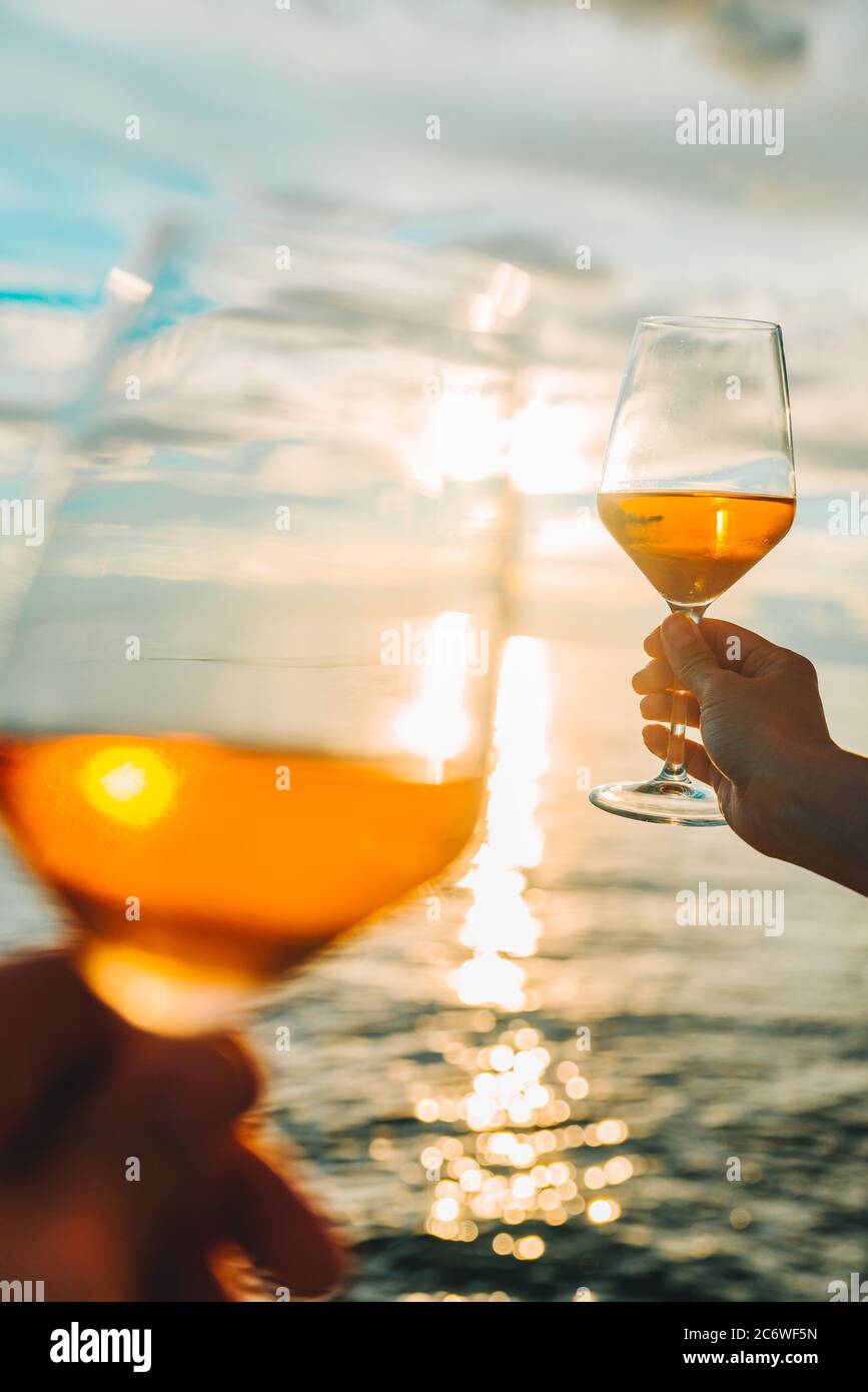 couple resting on sunset at sea beach and drinking wine Stock Photo - Alamy