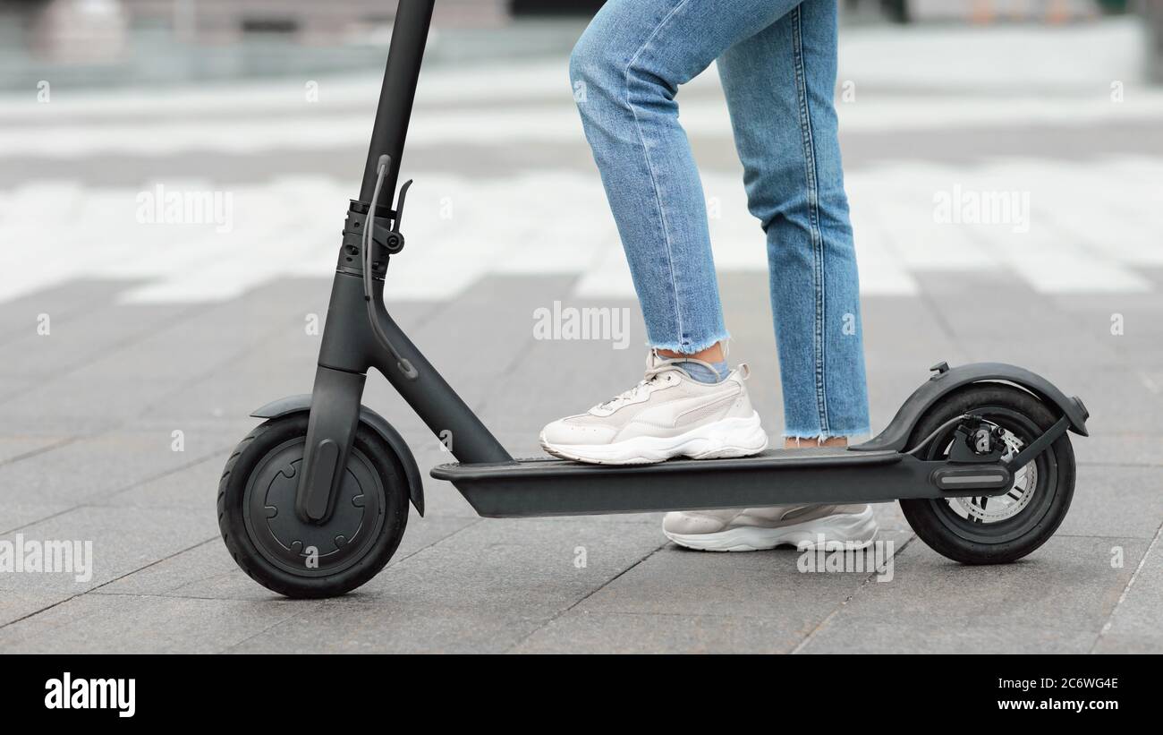 Girl standing on electric kick scooter outdoors Stock Photo Alamy