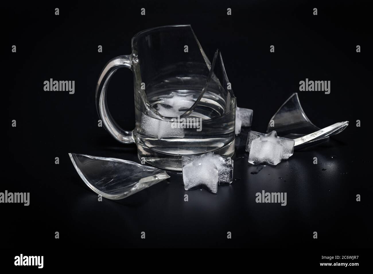 https://c8.alamy.com/comp/2C6WJR7/broken-glass-cup-with-splinters-water-and-ice-on-a-black-background-2C6WJR7.jpg